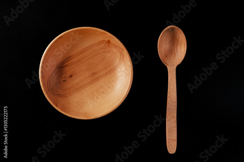 Eco-friendly cutlery made of wood. Spoon and plate on a black background