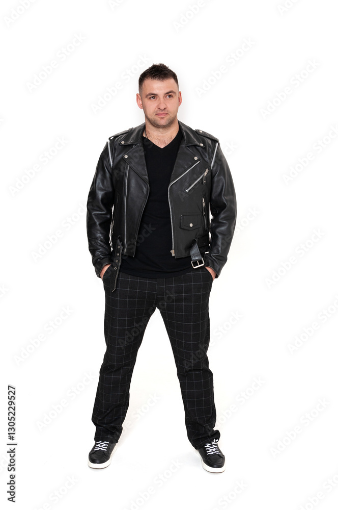 A handsome dark-haired man in a black leather jacket, black T-shirt, trousers and sneakers on a white background A handsome dark-haired man in a black leather jacket, black T-shirt, trousers and sneakers on a white background