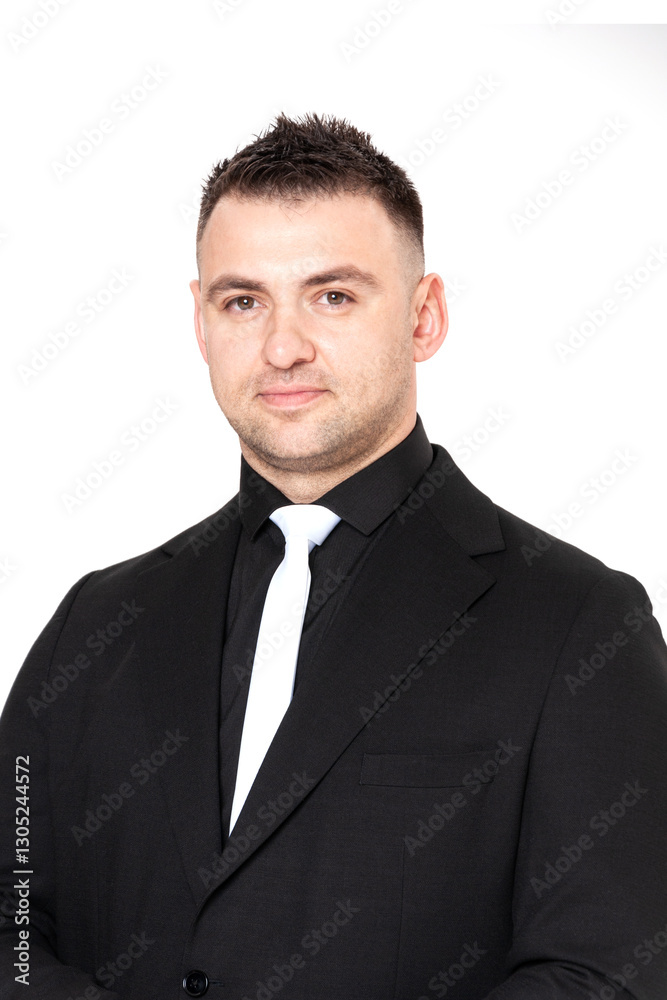 A handsome dark-haired man wearing a business suit, a black shirt on a white background A handsome dark-haired man wearing a business suit, a black shirt on a white background