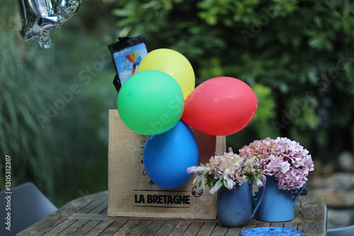 Summer garden birthday party with balloons, cake, and lit candles. Festive atmosphere outdoors with colorful decorations and joyful celebration under sunny skies.