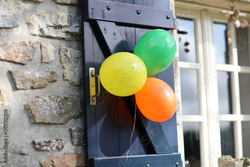 Summer garden birthday party with balloons, cake, and lit candles. Festive atmosphere outdoors with colorful decorations and joyful celebration under sunny skies.