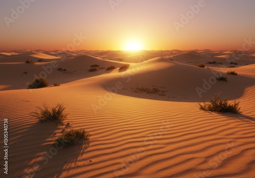 A desert landscape at sunset with rolling sand dunes and golden light.

