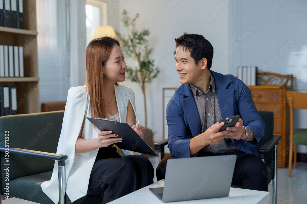 Фотография Business professionals collaborating, smiling while reviewing documents on lapto