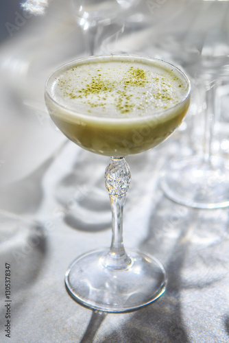 The image shows a beautifully presented matcha green tea latte or cocktail. 