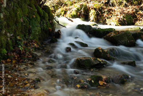 Slow shutter speed picture of the river flow in Polcenigo with pebbles and moss, in Friuli (Italy). We can apreciate the extreme motion blur