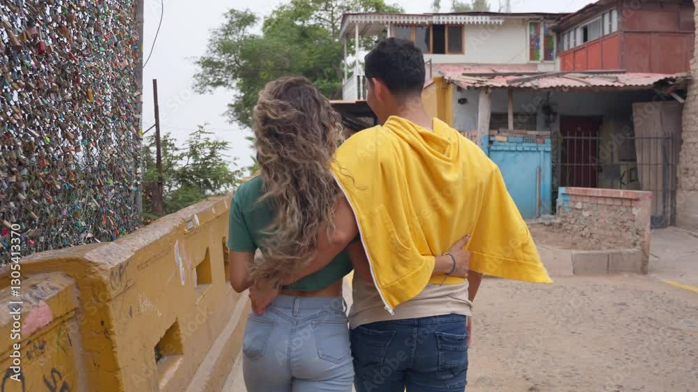 Young couple walking on bridge, embracing and talking Young couple walking on bridge, embracing and talking