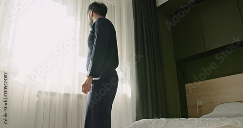A young Caucasian man wakes up and falls back asleep. The man is tired and doesn't want to get out of bed in the morning. photo