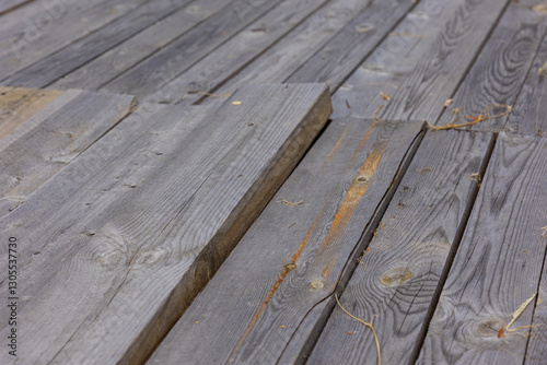 A broken temporary wooden deck for moving around the territory. Outside, the flooring is made of untreated wooden planks.