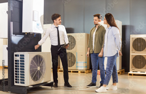 A couple in a store is interested in purchasing a household air conditioner, close-up. A male salesman demonstrates a household appliance for cooling a house. Concept air conditioner