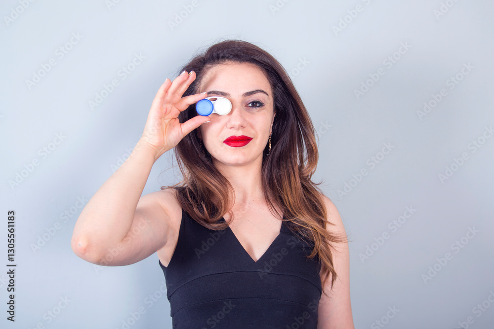 young woman hand holding lenses in eyes
