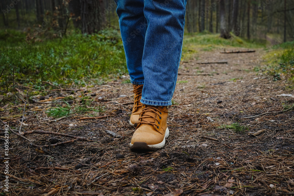 Close-up of a girl’s legs in jeans and hiking boots walking through a forest, path covered with pine needles, surrounded by pine trees, peaceful nature walk” Close-up of a girl’s legs in jeans and hiking boots walking through a forest, path covered with pine needles, surrounded by pine trees, peaceful nature walk”