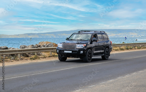 SUV driving on road along sea coast