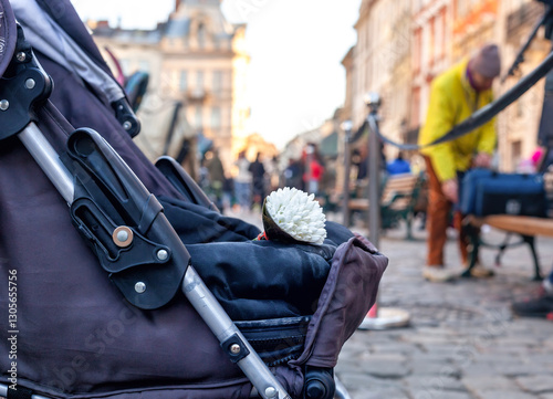 Baby carriage with bouquet of white flowers in Lviv, Ukraine