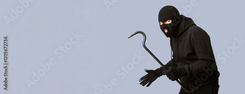 Cat Burglar Concept. Portrait of sneaky masked criminal holding crowbar, copy space, isolated over white studio wall