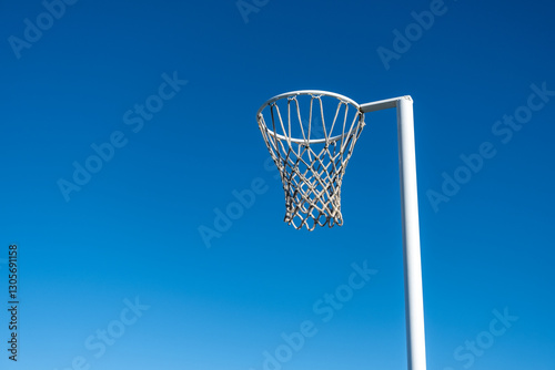 Vászonkép a netball hoop with a white metal pole against a clear blue sky background