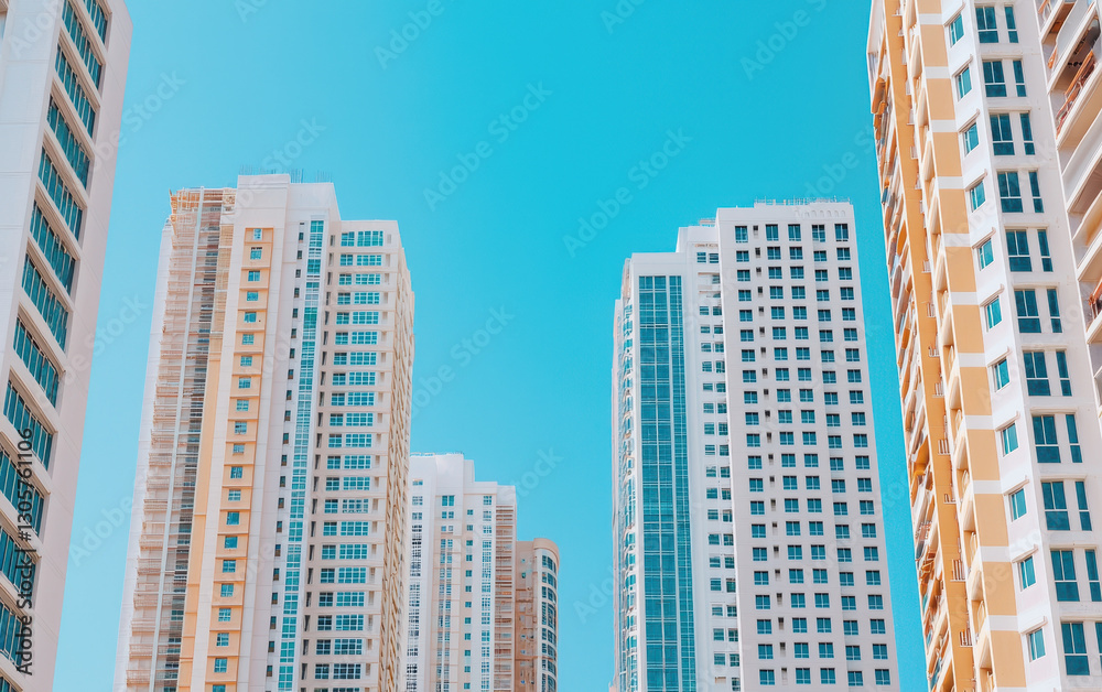 Fototapeta premium Modern high rise buildings against clear blue sky, showcasing urban architecture and design