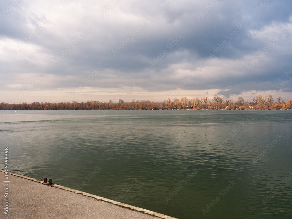 Cloudy sky over calm Danube river and shore Cloudy sky over calm Danube river and shore
