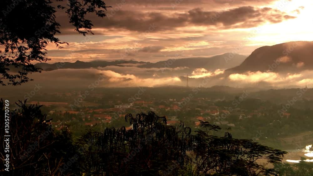Un paysage montagneux baigné de lumière dorée avec des nuages flottant au crépuscule