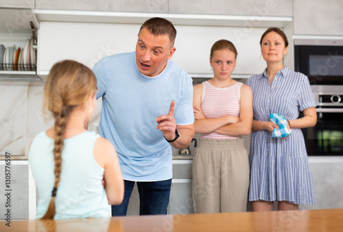 Family scene in kitchen, unpleasant conversation Parents stand face to face with daughter and scold for disobedience, unreasonable behavior