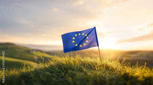 Flag of the EU planted on grassy hilltop, soft golden sunset light, rich blue and green tones, and peaceful tranquil atmosphere, wide-angle shot.