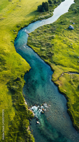 Aerial view revealing turquoise river winding through verdant valley, highlighting pristine natural landscape from high above