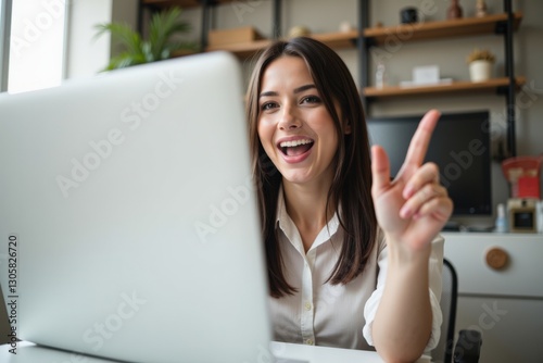 Free Download A Young Caucasian Woman with Long Dark Hair, Wearing a White Shirt, Joyfully Engaged in a Video Call at Her Modern Workspace, Surrounded by Indoor Plants and Contemporary Decor - GFXLoad