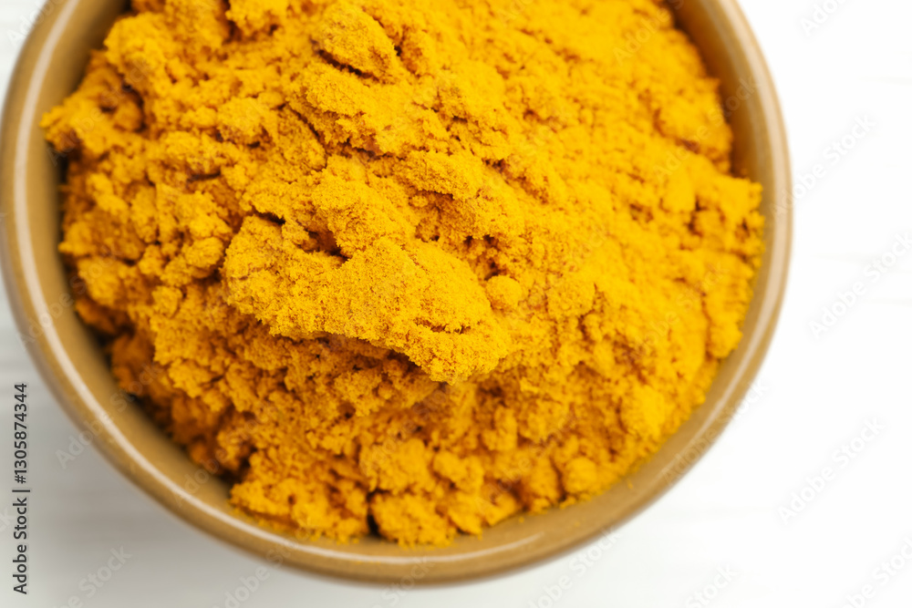 Turmeric powder in bowl on white wooden table, closeup. Top view Turmeric powder in bowl on white wooden table, closeup. Top view