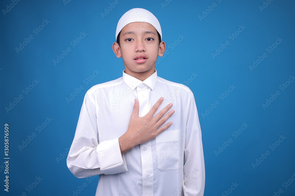 Shocked Asian Muslim Boy Isolated on Blue Background Shocked Asian Muslim Boy Isolated on Blue Background