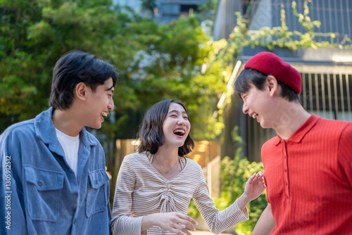 Diverse Asian friends chatting with each other outdoors in scenic park. 