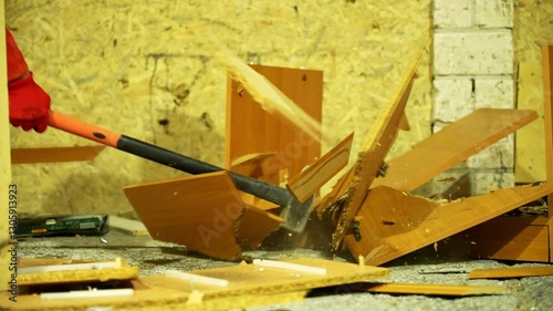 A man in protective gear and safety goggles aggressively smashes household items in a smash room, creating a chaotic yet thrilling scene of destruction and stress relief.