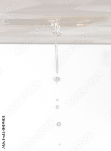 Ceiling Water leak from rain or broken pipe. House Water leaking on ceiling tile board and create dirty stain of flowing water, black background isolated