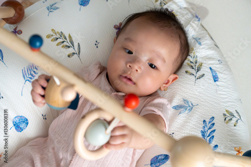 A 5-month-old newborn baby is happily playing with toys.