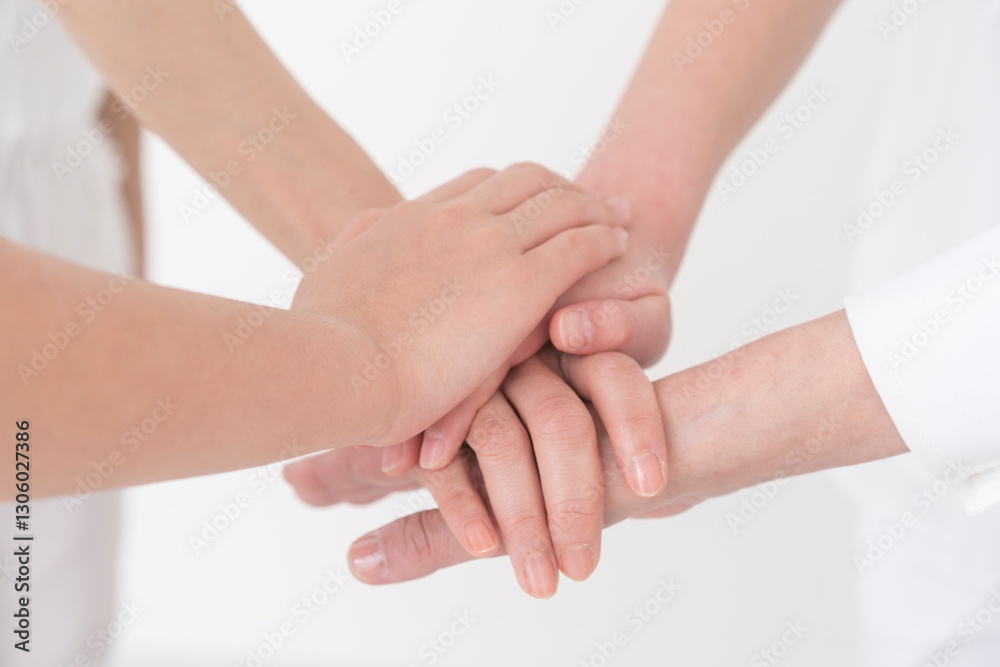 子供と大人が手を重ねている。/白背景スタジオ撮影