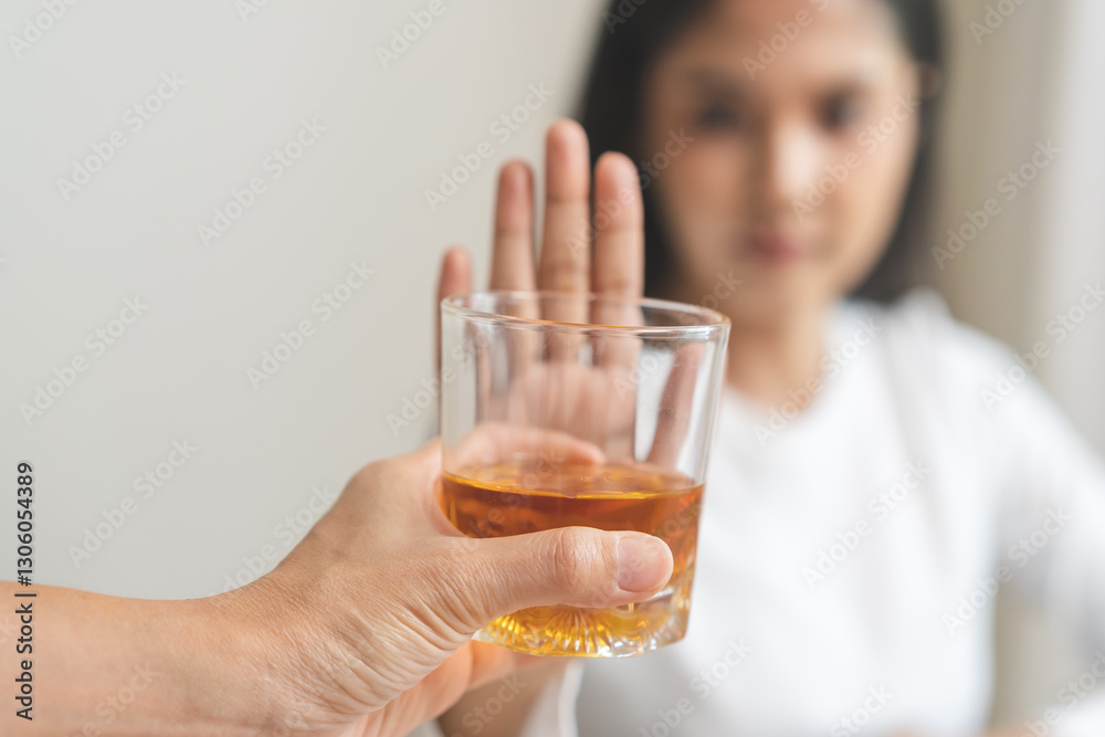 Alcoholism, depressed asian young woman hand refuse alcoholic beverage, drink whiskey while person holding glass give to her. Treatment of alcohol addiction, having suffered abuse problem alcoholism. Alcoholism, depressed asian young woman hand refuse alcoholic beverage, drink whiskey while person holding glass give to her. Treatment of alcohol addiction, having suffered abuse problem alcoholism.