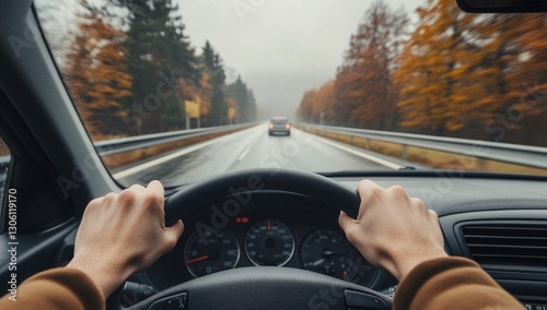 A person driving on the highway, hands tightly gripping the steering wheel. The view is from inside their car as they drive along an empty road with trees lining its sides.
