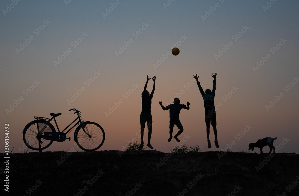 Golden hour silhouette of children playing with a ball.
