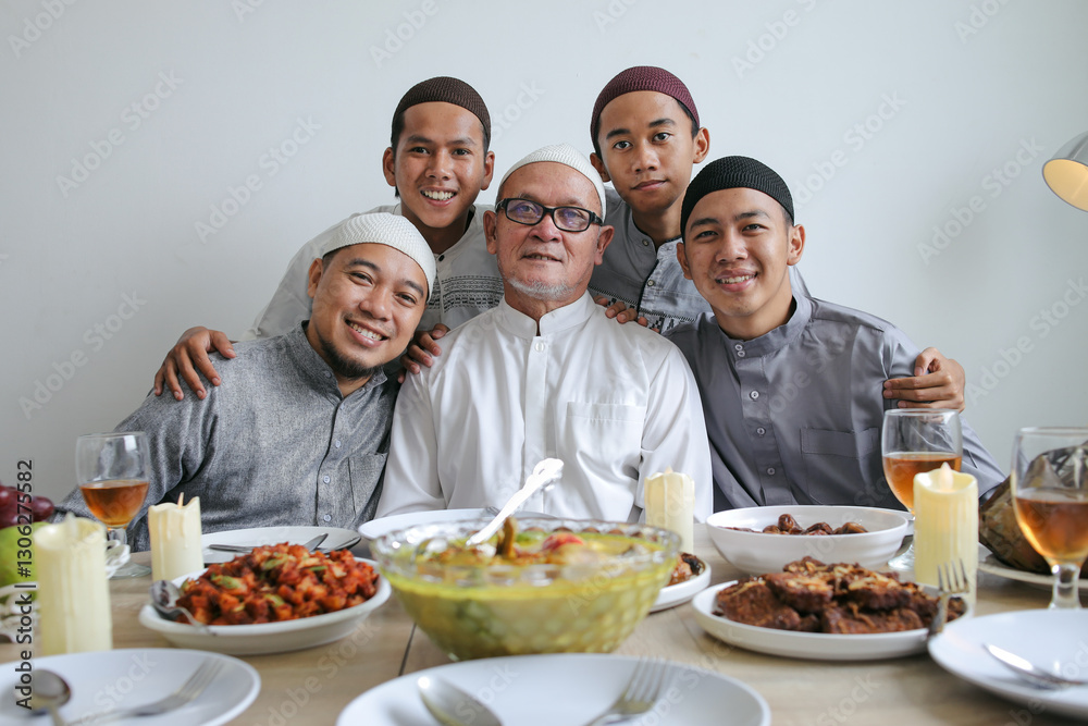 Portrait Of Multi Generation Muslim Family Smiling At Camera In Front Of Special Food Served On The Table During Eid Mubarak Celebration Portrait Of Multi Generation Muslim Family Smiling At Camera In Front Of Special Food Served On The Table During Eid Mubarak Celebration