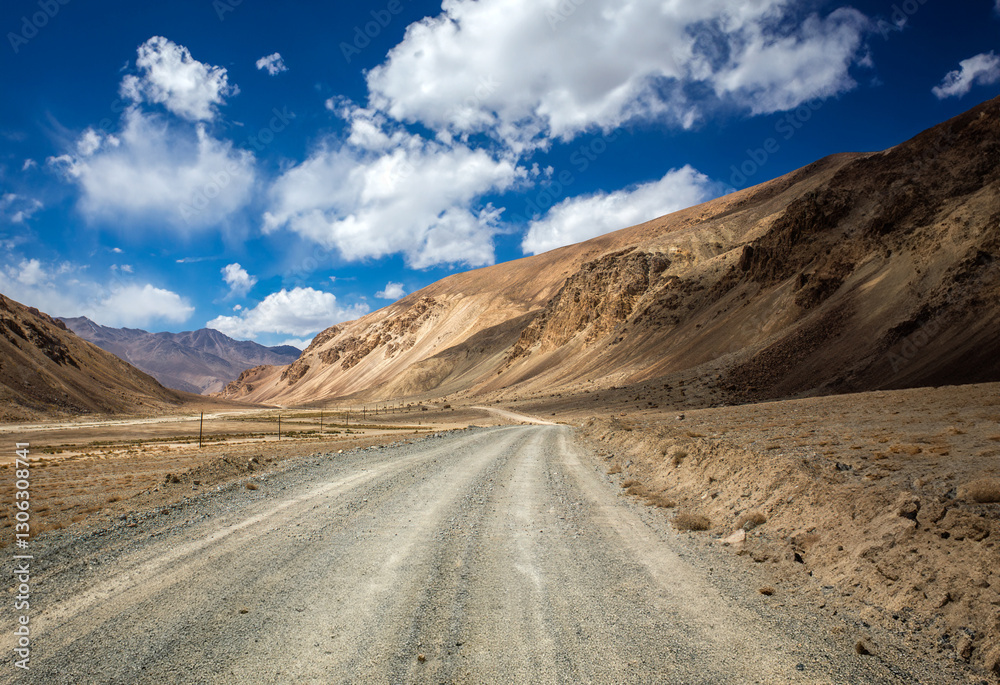 A road in the desert with a blue sky in the background A road in the desert with a blue sky in the background