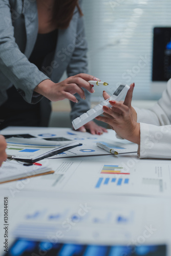 Businesswomen calculating tax using calculator in office meeting