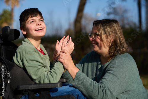 Obraz na plátně Therapist assisting child with disability in wheelchair outdoors - cerebral pals