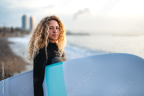 Joyful young woman carrying a surfboard on a beach, her face filled with happiness and excitement
