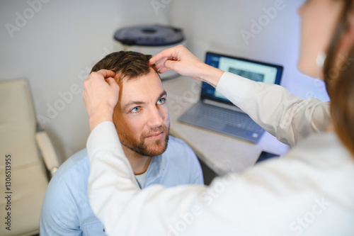 A trichologist examines the hair of a man who begins alopecia. Consultation with a dermatologist. Hair loss, alopecia, pruritus
