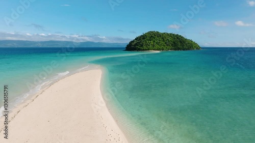 A tropical island surrounded by calm turquoise waters and a sandbar stretching into the sea. Bon Bon Beach, Romblon, Philippines.