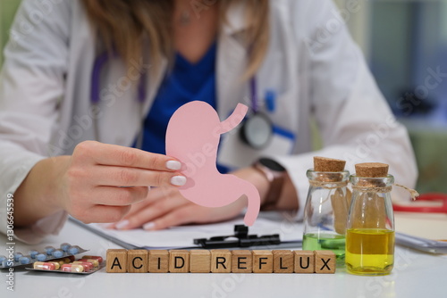 A medical professional is speaking about acid reflux while using a detailed stomach model to explain treatments