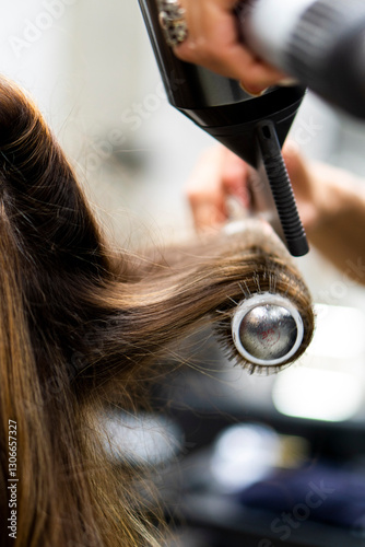 Hair treatments at the hairdressing salon. Female hairdresser's hands brushing and blow drying blonde hair in beauty salon. Hairdresser cutting client's hair with scissors in salon