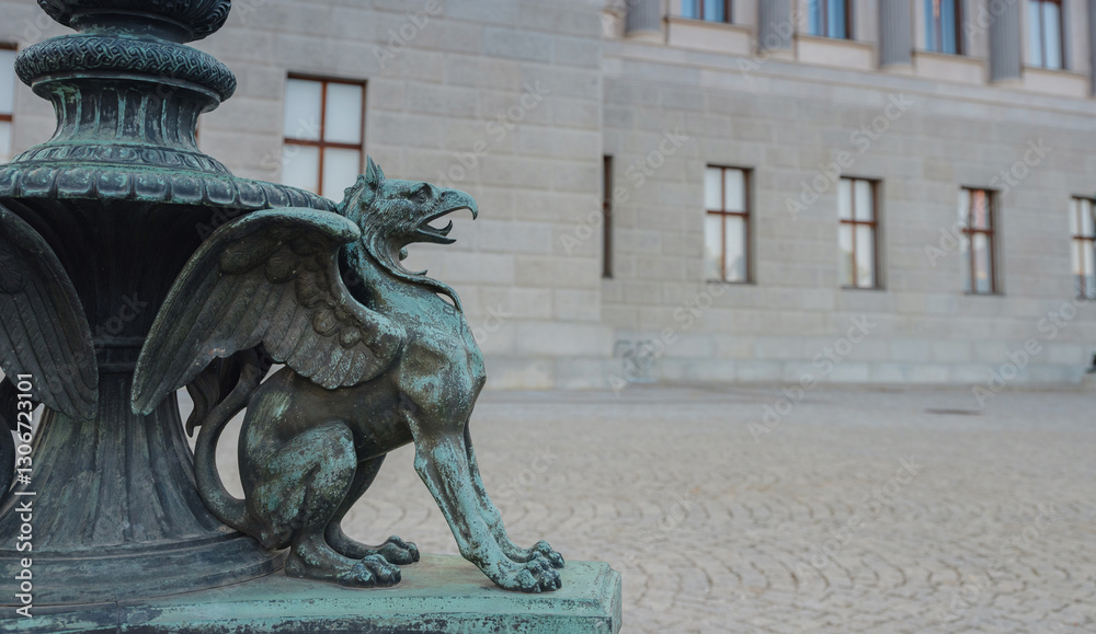 Naklejka premium Gryphon in front of Parliament in Vienna, Austria. Majestic Austrian Parliament Building, an iconic symbol of democracy, captured in warm sunlight against vibrant cityscape.