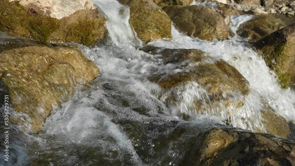 Slow-motion capture of water flowing over rocks in the Swiss Alps, near Walensee. The gentle cascade creates a soothing and peaceful scene, natural beauty and tranquility of the alpine landscape. Slow-motion capture of water flowing over rocks in the Swiss Alps, near Walensee. The gentle cascade creates a soothing and peaceful scene, natural beauty and tranquility of the alpine landscape.