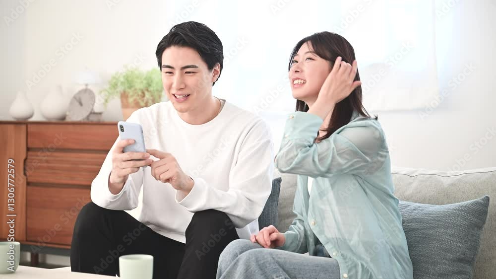 スマホを見る夫婦、画面に指を差す　家や何かを検索を探すイメージの動画