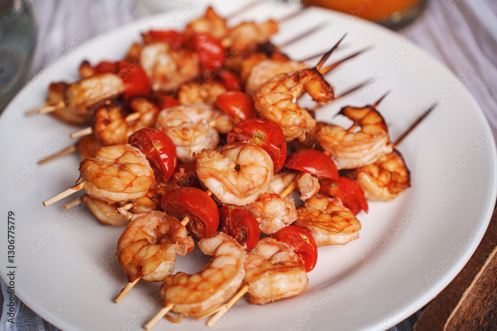 Skewers with shrimps and tomatoes on a white plate. Skewers with shrimps and tomatoes on a white plate.