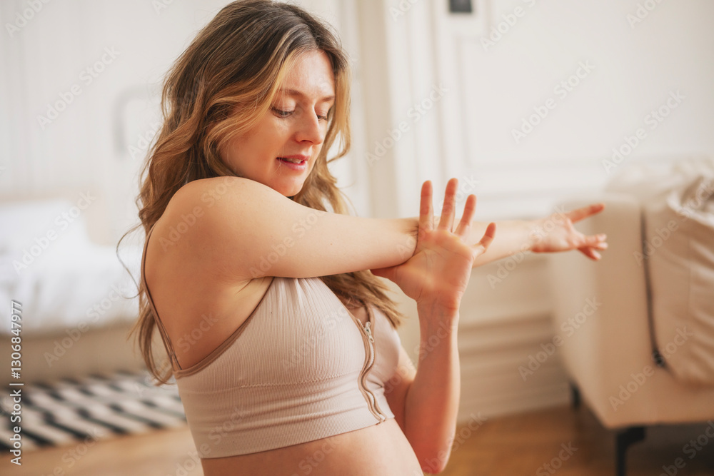 Young caucasian pregnant woman doing yoga and stretching at home in living room Young caucasian pregnant woman doing yoga and stretching at home in living room